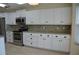Modern kitchen featuring white cabinets, granite countertops, and stainless steel appliances at 6548 Sw 84Th Place Rd, Ocala, FL 34476