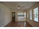 Open living room with wood floors, a ceiling fan, and views into the kitchen and to the outside at 6548 Sw 84Th Place Rd, Ocala, FL 34476