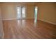 Spacious living room featuring hardwood floors, neutral walls, and access to outdoor patio through French doors at 6548 Sw 84Th Place Rd, Ocala, FL 34476