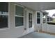 An exterior patio features a concrete floor, several windows and a white door, and a white fence at 6548 Sw 84Th Place Rd, Ocala, FL 34476
