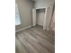 Bedroom showcasing wood-look floors, neutral paint, and closet with shelving at 6884 Sw 149Th Lane Rd, Ocala, FL 34473