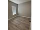 Bedroom featuring neutral paint, window, and wood-look flooring at 6884 Sw 149Th Lane Rd, Ocala, FL 34473