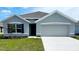Charming single-story home with a gray exterior, well-manicured lawn, and attached two-car garage at 7137 Se 113Th Ln, Belleview, FL 34420