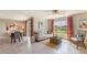 Bright living room with views of the backyard lake, cozy seating, and tile flooring at 7137 Se 113Th Ln, Belleview, FL 34420