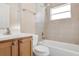 Bathroom featuring tiled shower-tub combo, white toilet, and light wood vanity with sink at 811 Niles St, Daytona Beach, FL 32114