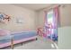 Cozy bedroom featuring light pink decor, plush carpet, and a window with natural light at 811 Niles St, Daytona Beach, FL 32114