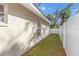 Narrow side yard enclosed by a new white fence at 811 Niles St, Daytona Beach, FL 32114