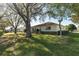 A neatly maintained backyard with a lawn and hedge and the rear of the house is shown at 8740 Se 140Th Place Rd, Summerfield, FL 34491