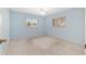 Bright bedroom with light blue walls, neutral carpet, ceiling fan, and two sunny windows at 8740 Se 140Th Place Rd, Summerfield, FL 34491