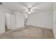 Open bedroom with neutral carpet leading to the hallway and bathroom with a white door at 8740 Se 140Th Place Rd, Summerfield, FL 34491