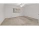 Bright bedroom with neutral carpet, ceiling fan, and window for natural light at 8740 Se 140Th Place Rd, Summerfield, FL 34491