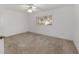 Spacious bedroom with neutral carpet, ceiling fan, and window for natural light at 8740 Se 140Th Place Rd, Summerfield, FL 34491