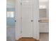 Hallway view into the bedroom with a door to the bathroom featuring a single vanity and mirror at 8740 Se 140Th Place Rd, Summerfield, FL 34491