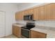Well-lit kitchen features stainless steel microwave and oven, upper and lower cabinets, and light countertops at 8740 Se 140Th Place Rd, Summerfield, FL 34491
