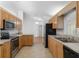 Functional kitchen featuring light wood cabinets, stainless appliances, and ample counter space at 8740 Se 140Th Place Rd, Summerfield, FL 34491