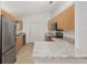 Bright kitchen with stainless steel refrigerator and oven, light wood cabinets, and a white door at 8740 Se 140Th Place Rd, Summerfield, FL 34491