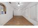 Large living space with wood floors, ceiling fans, and kitchen access at 8740 Se 140Th Place Rd, Summerfield, FL 34491