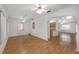 Open-concept living area with wood floors, ceiling fans, and access to kitchen at 8740 Se 140Th Place Rd, Summerfield, FL 34491