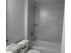 Modern bathroom with tiled shower, white tub, and sleek gray vanity at 9455 Se 152Nd Pl, Summerfield, FL 34491