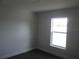 Empty bedroom featuring wood floors, base molding and a window with natural light at 9455 Se 152Nd Pl, Summerfield, FL 34491
