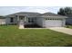 Charming single-story home with a well-manicured lawn, two-car garage, and inviting entrance at 9455 Se 152Nd Pl, Summerfield, FL 34491