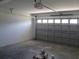 Spacious garage with an automatic door, brick walls, and a concrete floor at 9455 Se 152Nd Pl, Summerfield, FL 34491