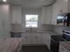 Well-equipped kitchen with white cabinets, granite countertops, stainless appliances, and a tiled backsplash at 9455 Se 152Nd Pl, Summerfield, FL 34491