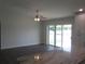 Open living room featuring stylish ceiling fan, sliding glass doors, and wood-look flooring at 9455 Se 152Nd Pl, Summerfield, FL 34491