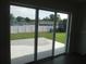 A view of the backyard through large sliding glass doors leading to a patio at 9455 Se 152Nd Pl, Summerfield, FL 34491