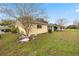 Large grassy yard with decorative landscaping and exterior view of the home with a screened lanai at 9710 Sw 96Th St, Ocala, FL 34481