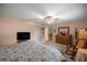 Spacious bedroom featuring a large bed, wooden furniture, soft carpet, and a ceiling fan at 9710 Sw 96Th St, Ocala, FL 34481