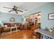 Open-concept living area with hardwood floors, a ceiling fan, a comfortable sofa, and easy access to the kitchen at 9710 Sw 96Th St, Ocala, FL 34481