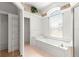 Bathroom showcasing a soaking tub with a large window and adjacent closet space at 11267 Sw 51St Ave, Ocala, FL 34476