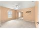 Bedroom featuring neutral carpet, a ceiling fan, and a closet with mirrored doors at 11267 Sw 51St Ave, Ocala, FL 34476