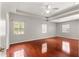 Large primary bedroom featuring hardwood floors, tray ceilings, a ceiling fan, and bright windows at 11267 Sw 51St Ave, Ocala, FL 34476