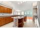 Open kitchen featuring granite counters, wooden cabinetry, an island, and tile flooring at 11267 Sw 51St Ave, Ocala, FL 34476