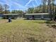 Large backyard with green lawn and two homes with green exteriors and wood decks at 11644 Nw 21St St, Ocala, FL 34482