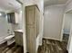 Bathroom featuring a shower and tub combo, a storage cabinet, and natural-look flooring at 11644 Nw 21St St, Ocala, FL 34482