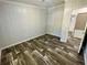 Bedroom featuring wood-look flooring, neutral walls, and a doorway to the bathroom at 11644 Nw 21St St, Ocala, FL 34482