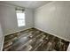 Bedroom with wood-look flooring, neutral walls, bright window, and white trim at 11644 Nw 21St St, Ocala, FL 34482
