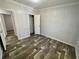 Bedroom with wood-look floors, closet, neutral walls, and white trim at 11644 Nw 21St St, Ocala, FL 34482
