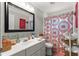 Bathroom with a decorative shower curtain and well-stocked shelves at 1192 Ne 130Th Ter, Silver Springs, FL 34488