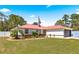 Charming home features a manicured lawn, vibrant landscaping, and a striking red roof at 1192 Ne 130Th Ter, Silver Springs, FL 34488