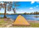 Beautiful lakefront view with a private wooden dock on a sunny day at 1192 Ne 130Th Ter, Silver Springs, FL 34488