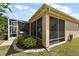 View of the back of the home featuring an enclosed patio area, garden, and lush green lawn at 12139 Se 91St Ter, Summerfield, FL 34491