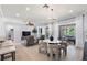 Open-concept living room featuring a ceiling fan, comfortable furniture, and dining area views at 12139 Se 91St Ter, Summerfield, FL 34491
