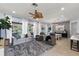 Bright living room with large windows, plush seating, and an elegant ceiling fan at 12139 Se 91St Ter, Summerfield, FL 34491