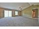 A spacious living room featuring neutral carpeting and ample natural light from a sliding glass door at 14230 Se 34Th Ct, Summerfield, FL 34491