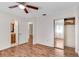 Bedroom features wood floors, white walls, ceiling fan, and closet with mirrored doors at 1505 Ne 33Rd Pl, Ocala, FL 34479