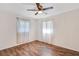 Bedroom has wood floors, white walls and two windows with sheer curtains at 1505 Ne 33Rd Pl, Ocala, FL 34479